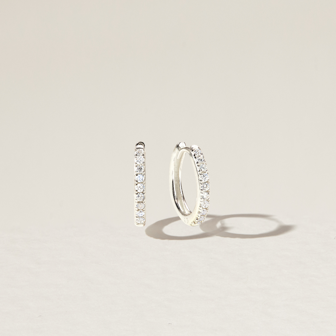 Silver diamond style large hoop earrings over a paper backdrop