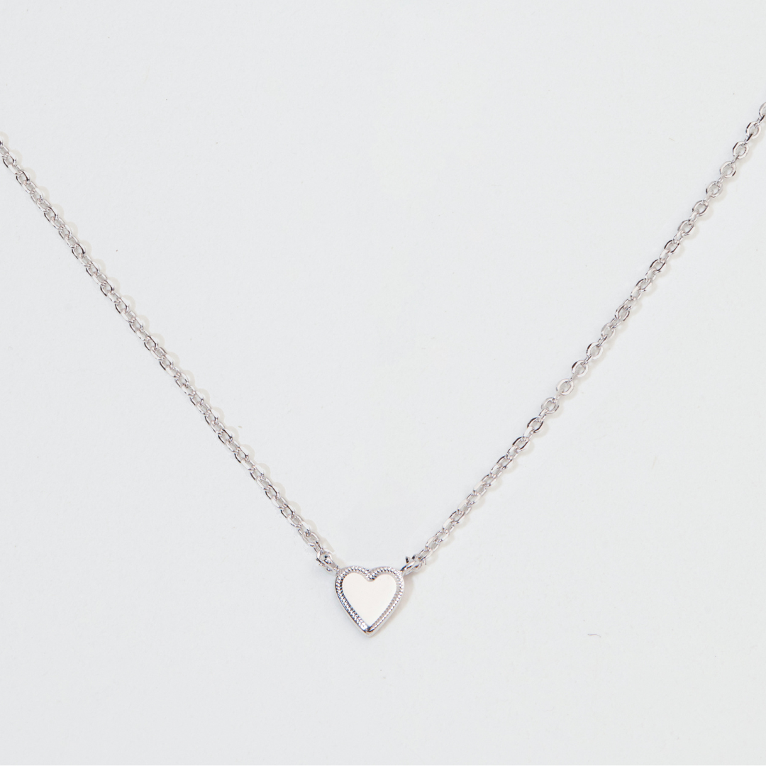 Silver tiny heart necklace close up on a white background
