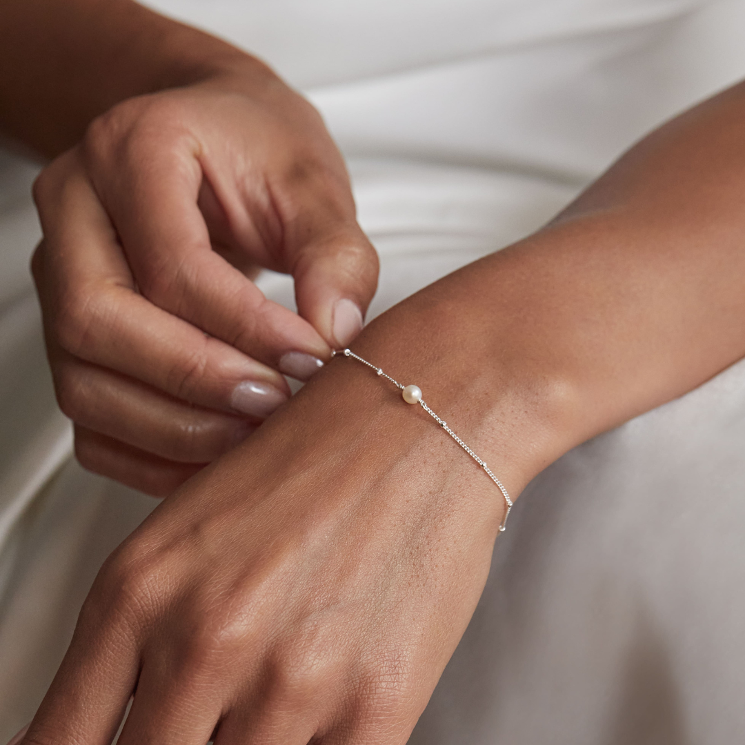 Silver satellite pearl bracelet around a wrist