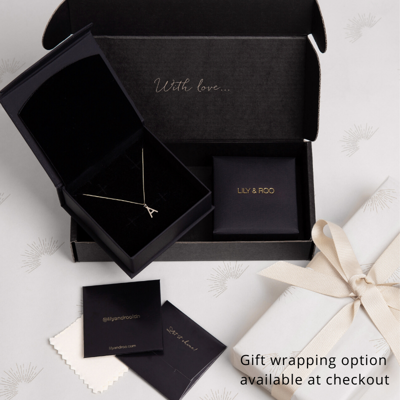 Black and white gift wrapping boxes, open and closed, one with a necklace inside