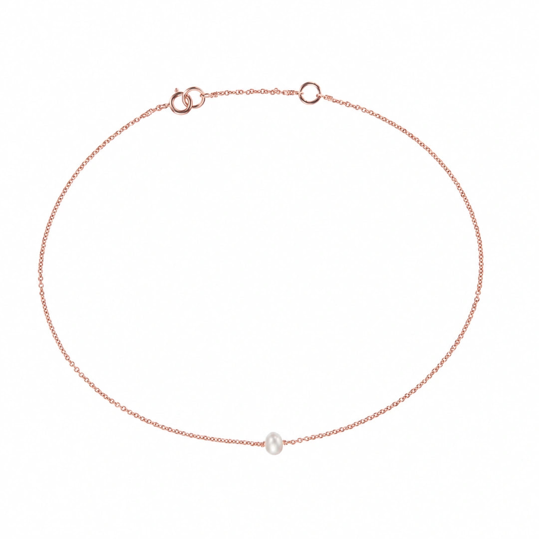 A delicate rose gold chain anklet featuring a single small white freshwater pearl, displayed on a clean white background.