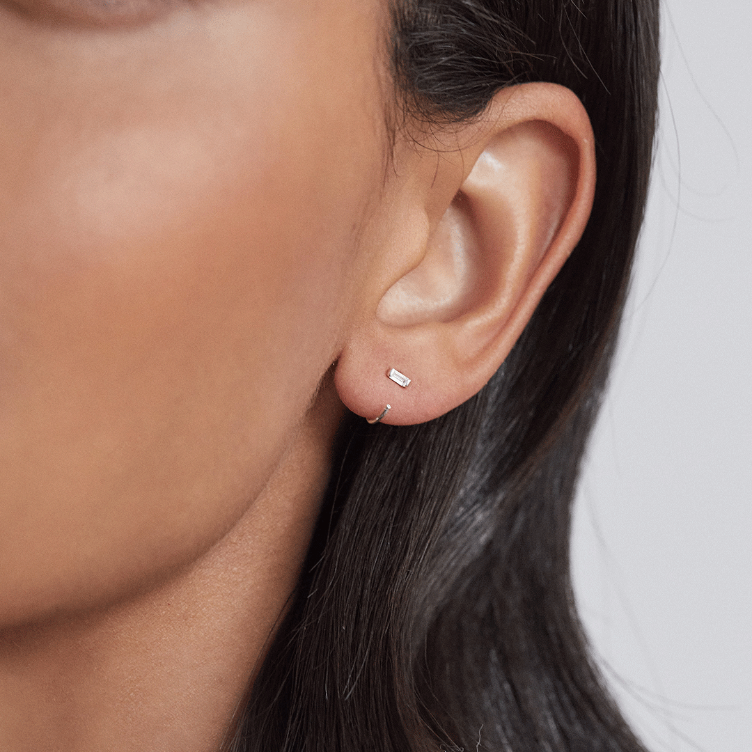 Silver diamond style baguette lobe hoop earring in one ear lobe