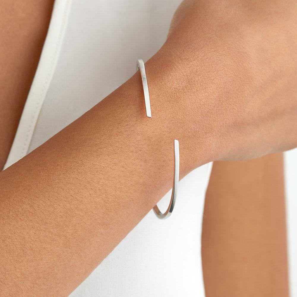 Silver thin spiral bangle around a wrist