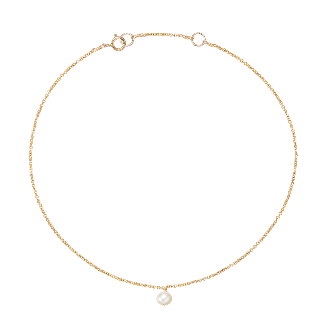 Gold single pearl drop anklet on a white background
