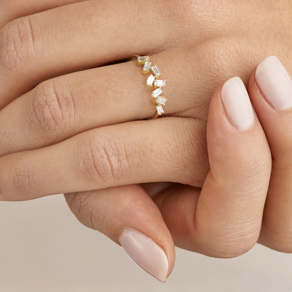 A silver diamond style baguette ring on a finger close up with her hands clasped