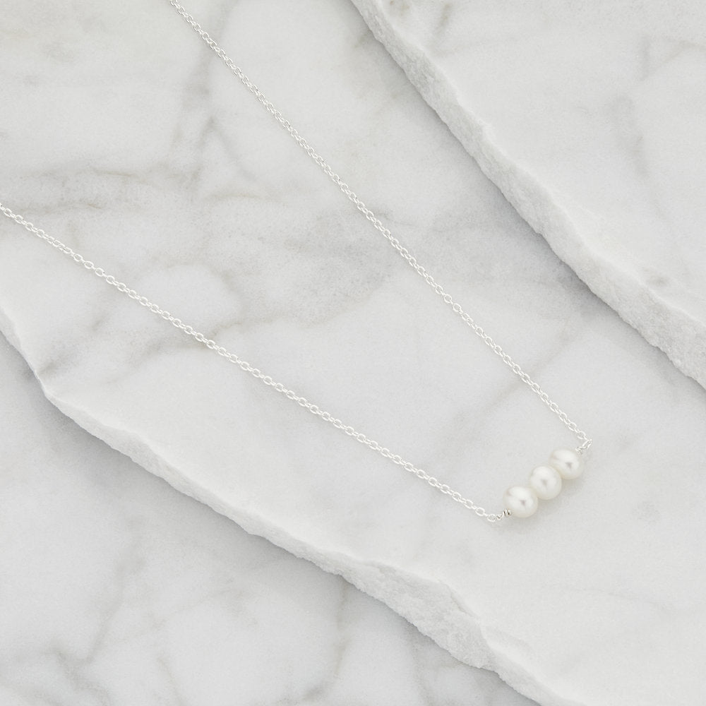 Silver cluster pearl choker on marble surfaces