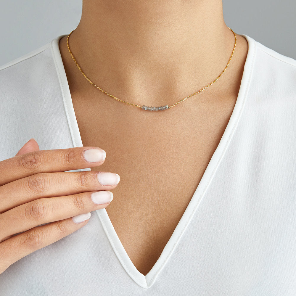Gold labradorite gemstone cluster choker around a neck with a white v neck top