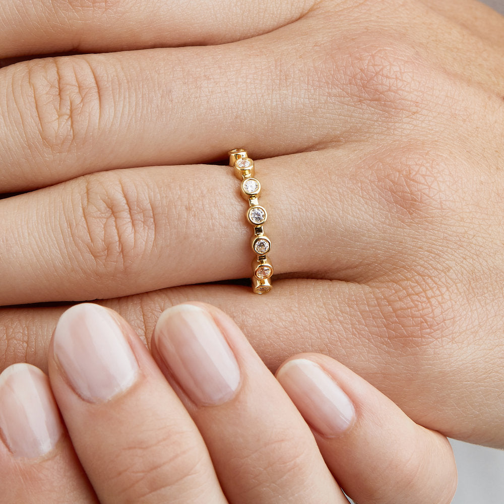 Gold diamond style round eternity ring on a finger close up