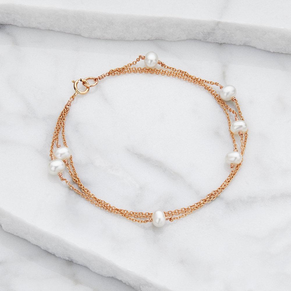 Gold layered pearl bracelet on marble surfaces
