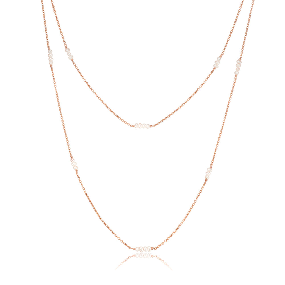 Rose gold layered mini pearl necklace on a white background
