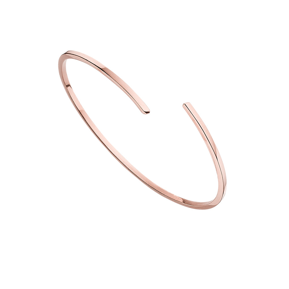 Rose gold thin spiral bangle on a white background