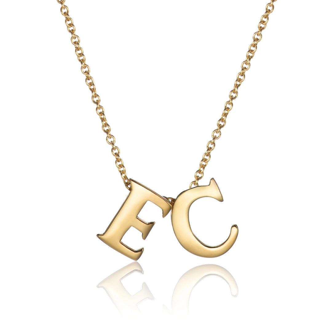 Gold necklace with 'EC' pendant on a white background
