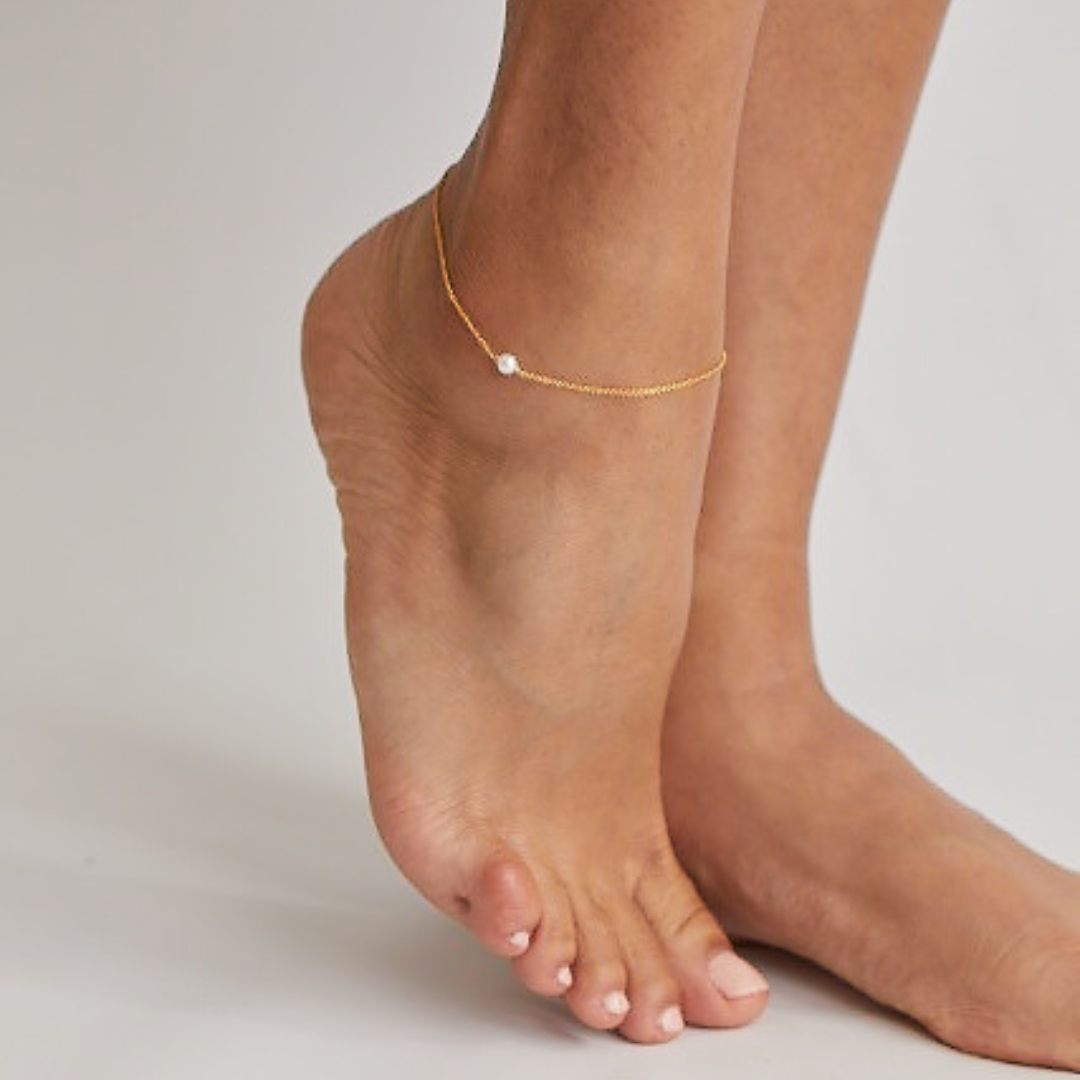 Gold small pearl anklet around an ankle