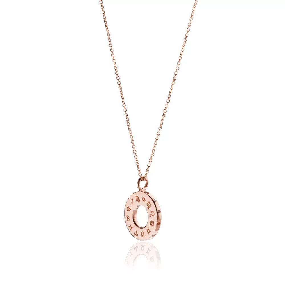 Rose gold zodiac birthstone necklace on a white background with a reflection below it