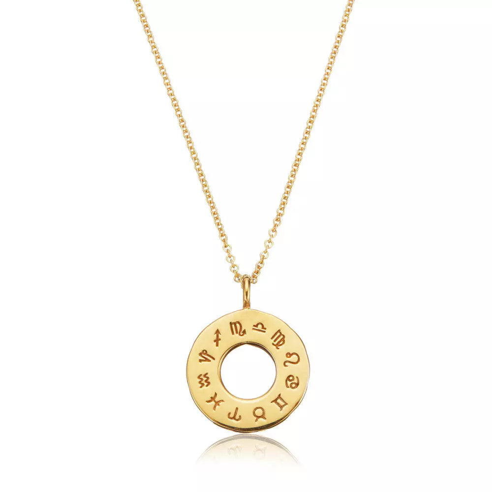 Gold zodiac birthstone necklace on a white background with it's reflection under it