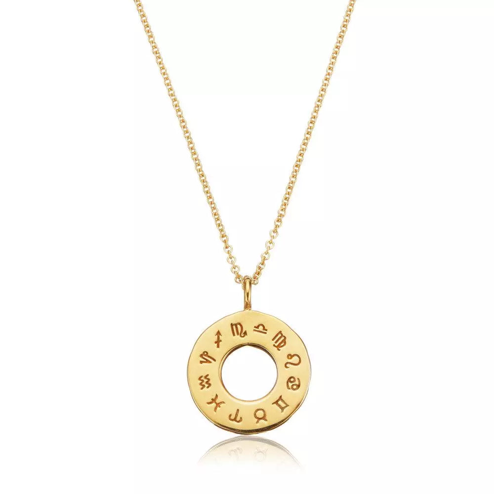 Gold zodiac birthstone necklace on a white background with a reflection below it