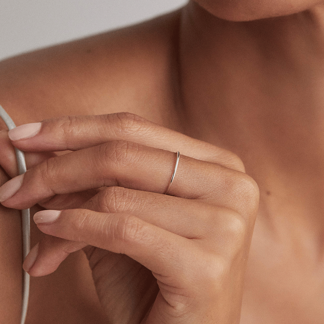 Silver thin plain stacking ring on a finger