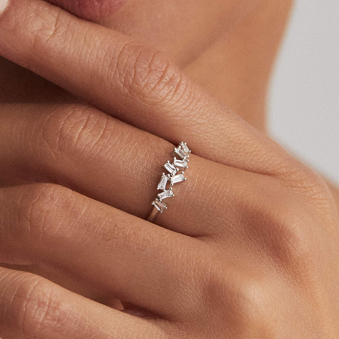 A silver diamond style baguette ring on a finger close up