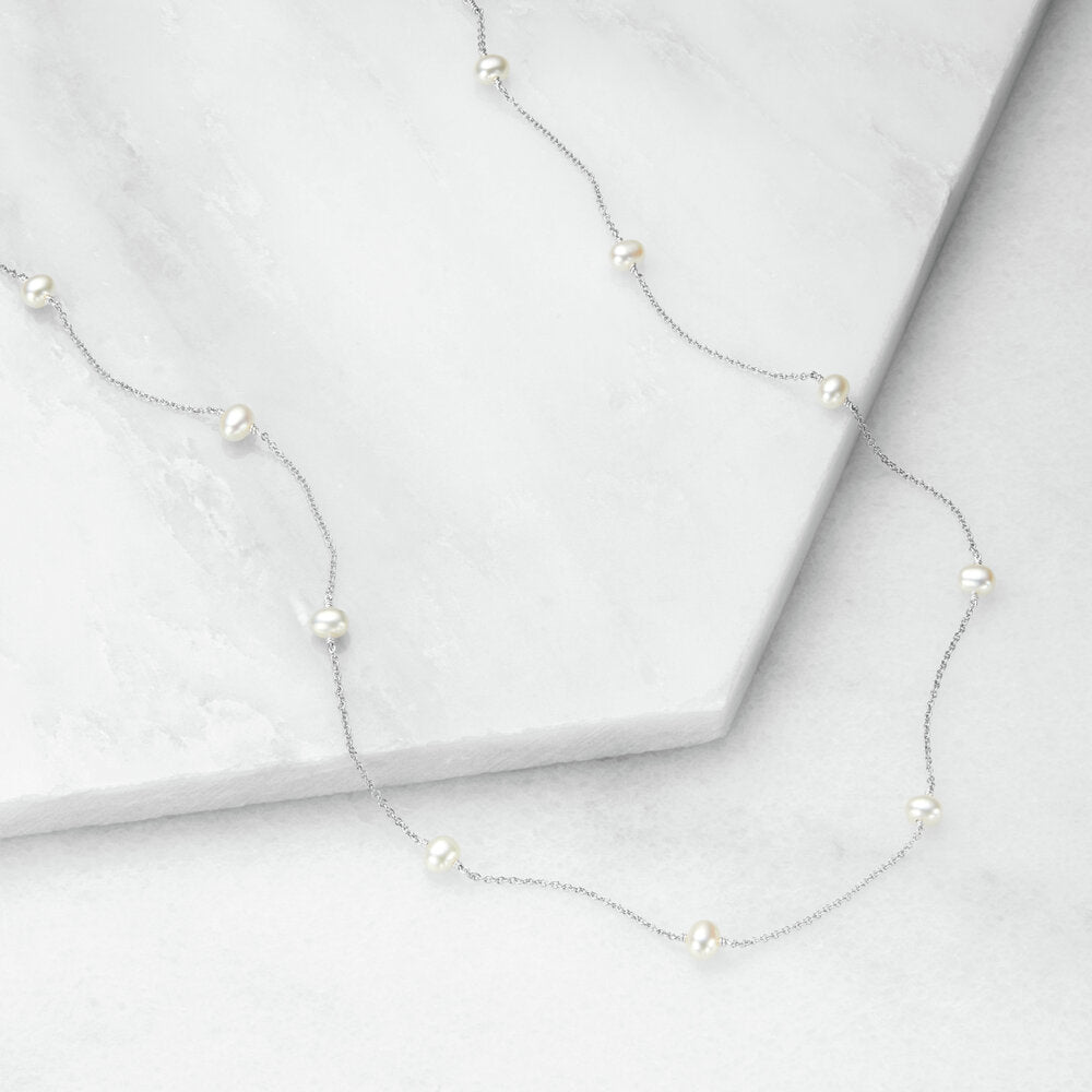 Silver ten pearl choker on marble surfaces