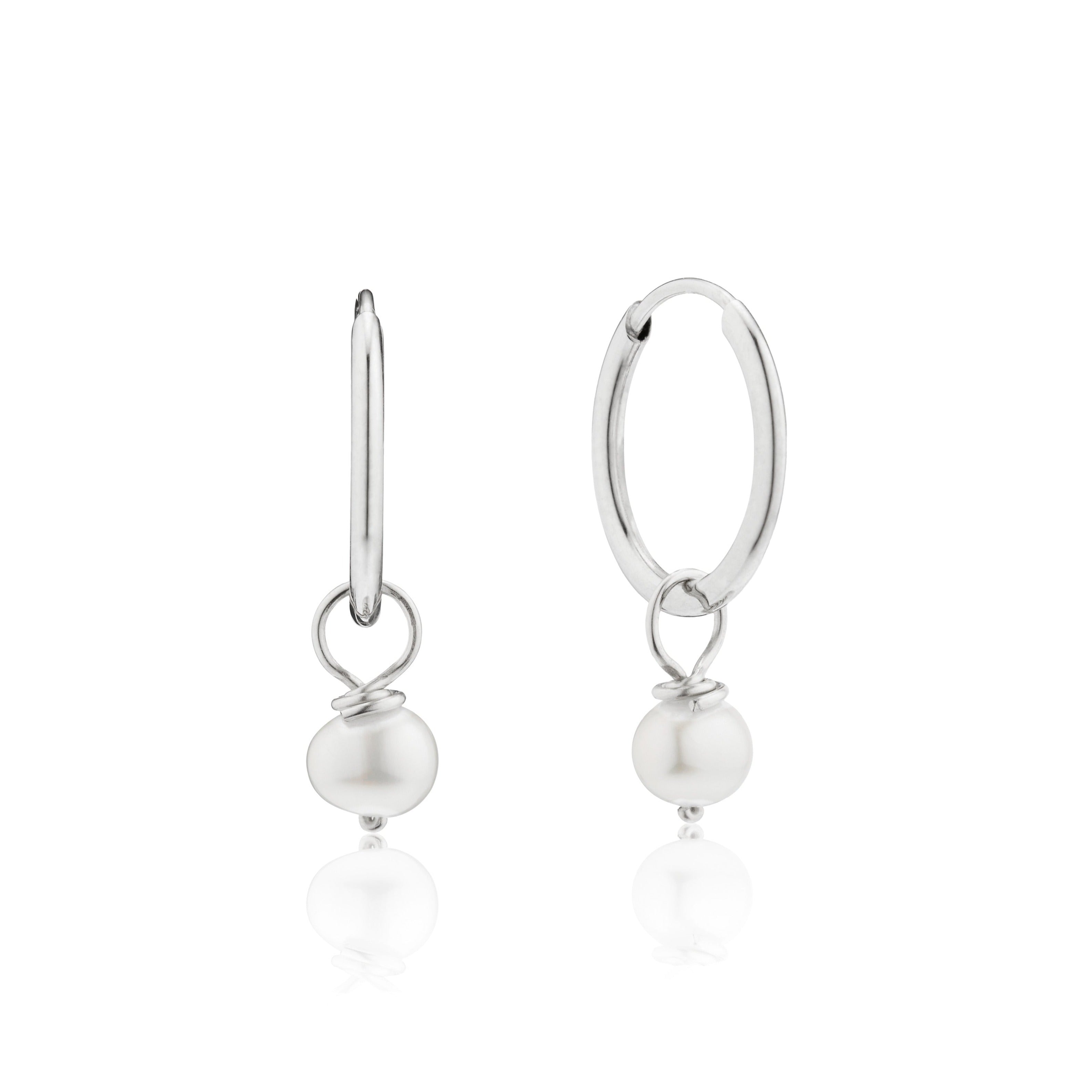 Silver small pearl drop hoop earrings on a white background