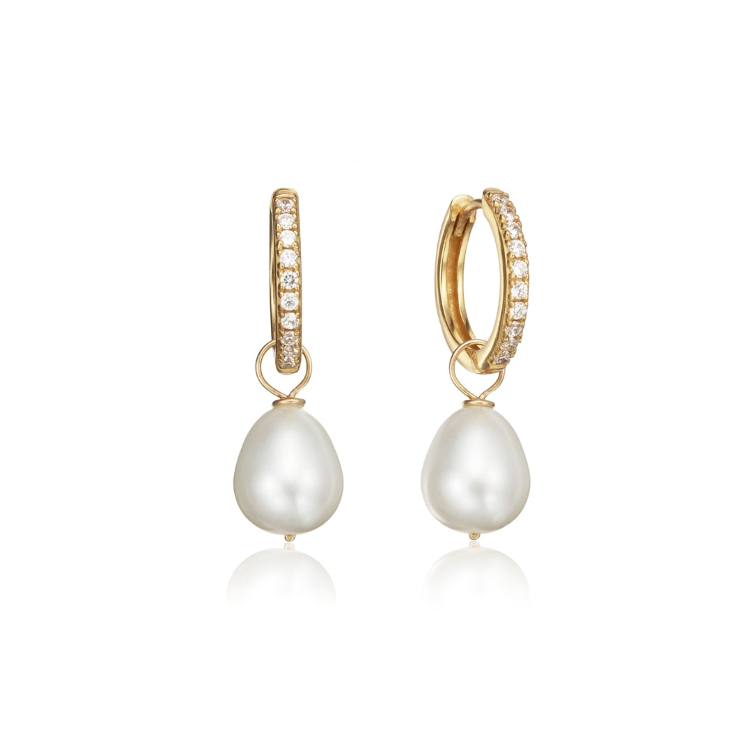 Gold diamond style large pearl drop hoop earrings on a white background