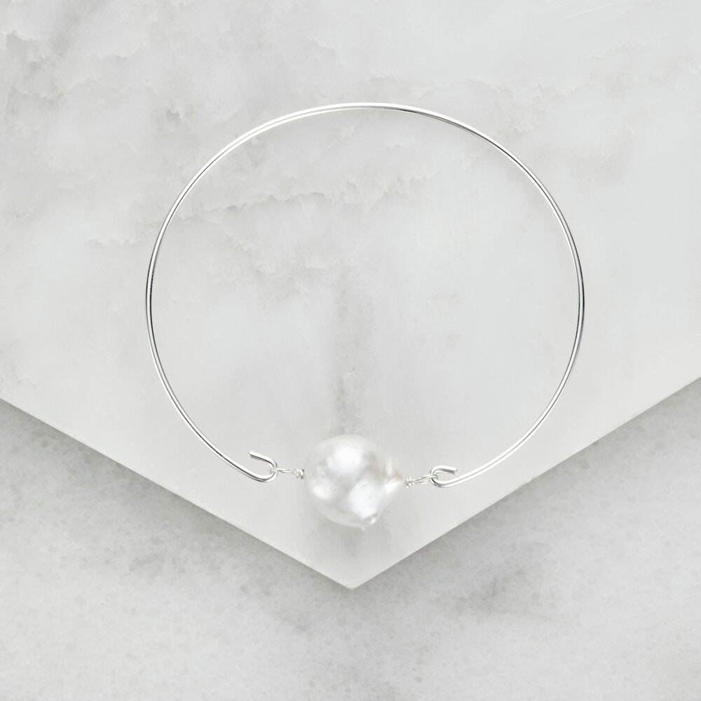 Silver baroque pearl bangle on marble surfaces