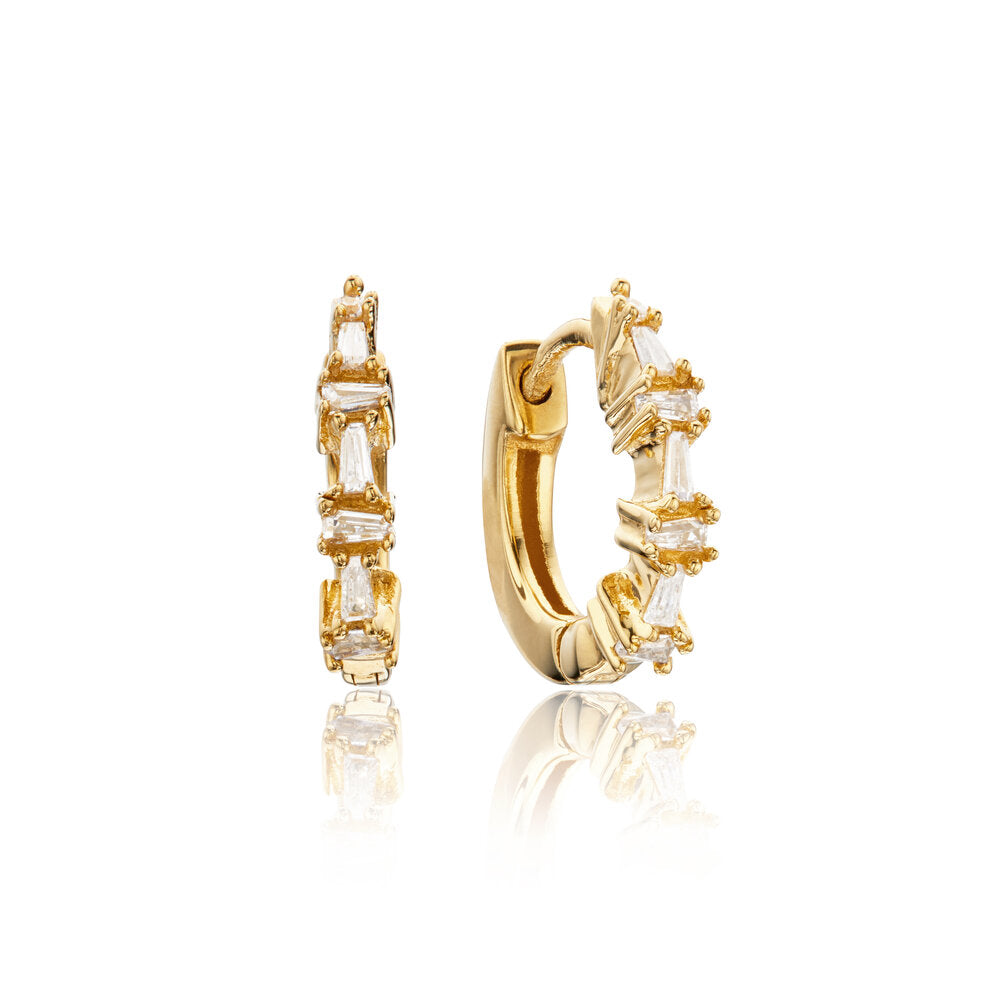 Gold diamond style baguette huggie hoop earrings on a white background 
