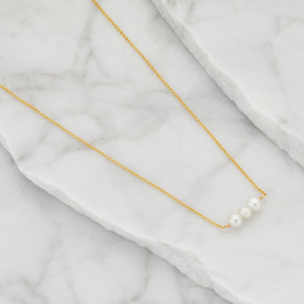 Gold cluster pearl choker on marble surfaces