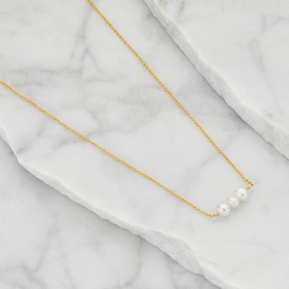 Gold cluster pearl choker on marble surfaces