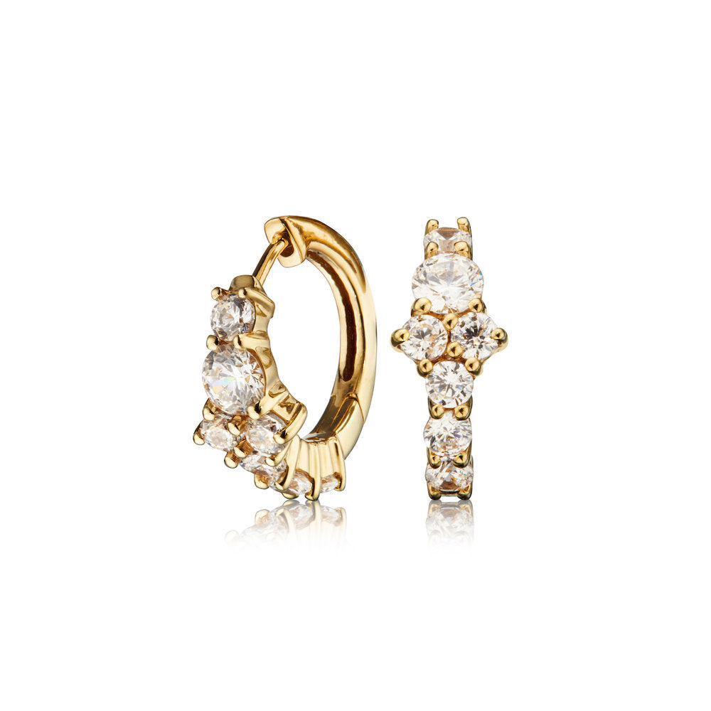 Gold diamond style cluster huggie hoop earrings on a white background 
