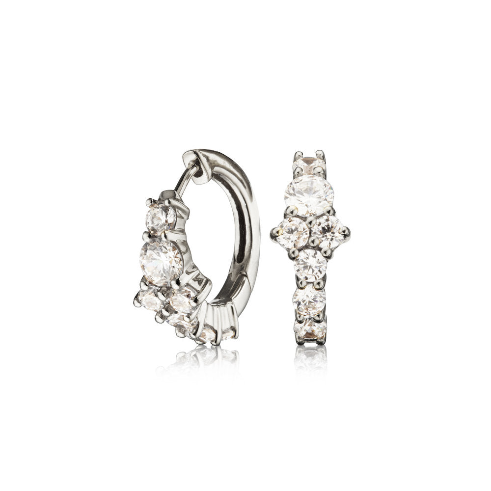 silver diamond style cluster huggie hoop earrings on a white background