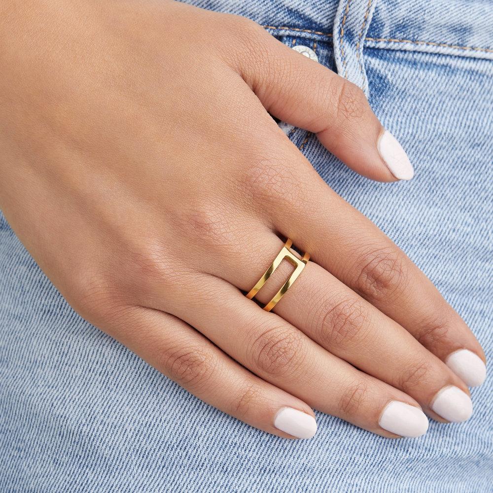 Gold double band ring on a hand over blue jeans