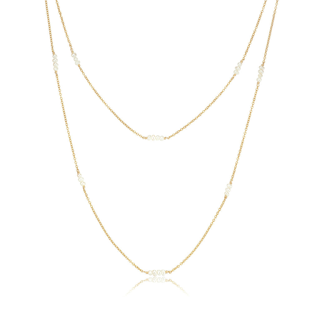 Gold layered mini pearl necklace on a white background