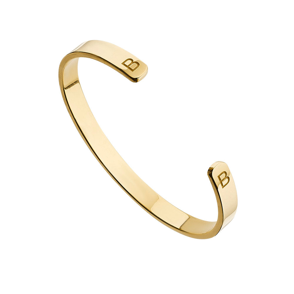 Gold thick engraved bangle with two of the letter 'B' engraved on a white background