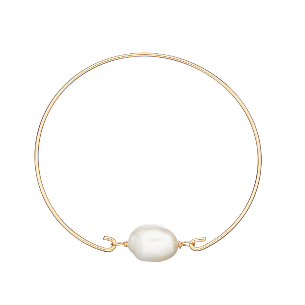 Gold large pearl bangle on a white background