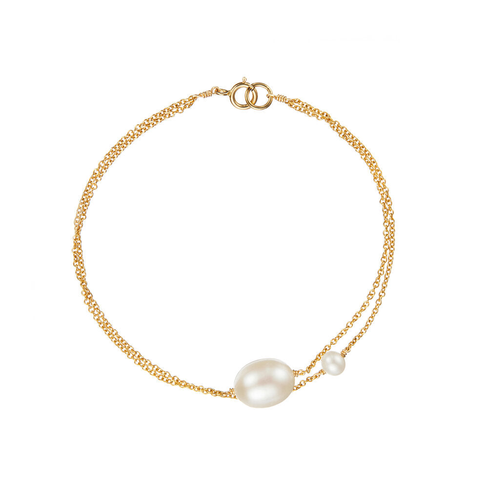 Gold layered large and small pearl bracelet on a white background