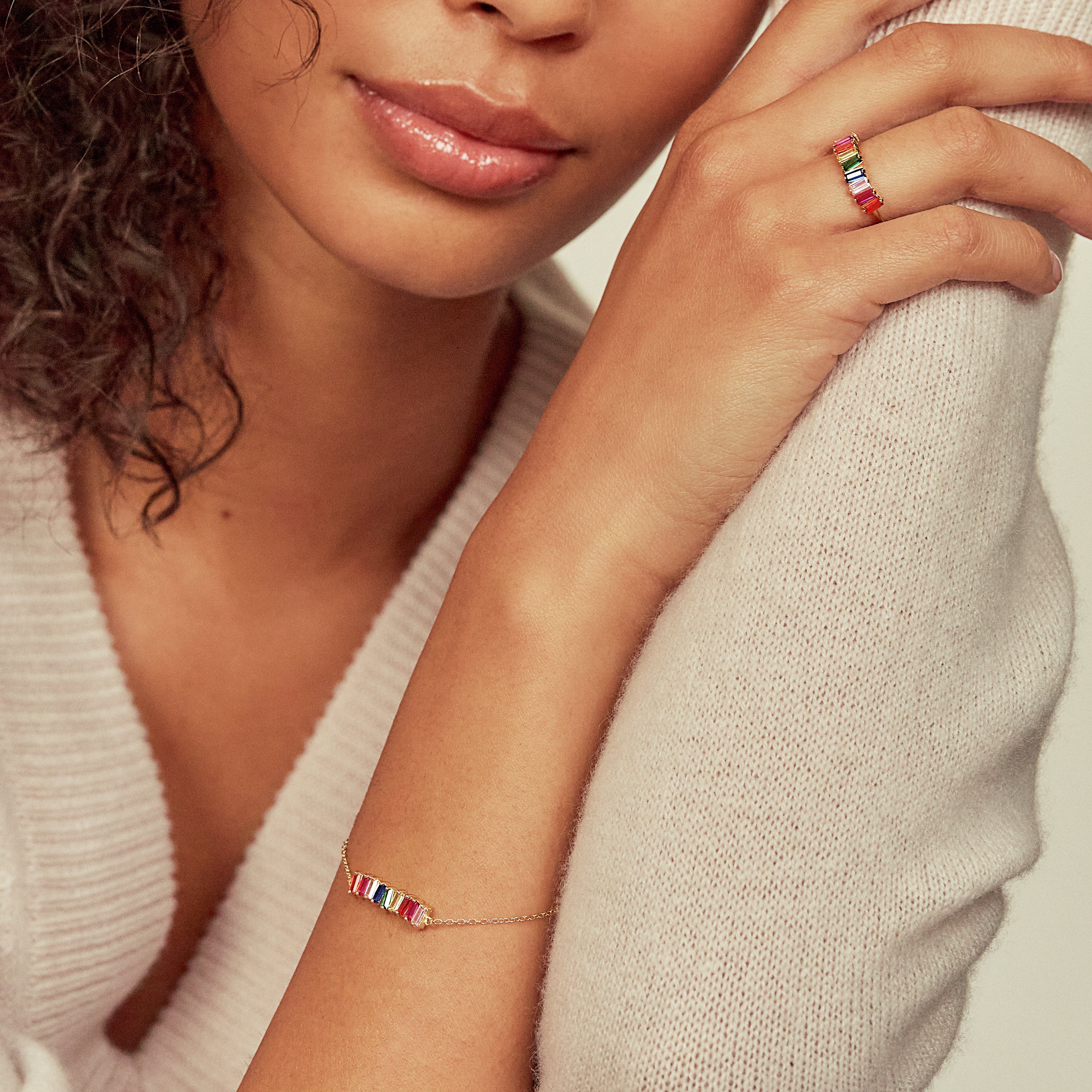 Gold rainbow gemstone cluster bracelet on a woman with a gold rainbow gemstone cluster ring on her finger