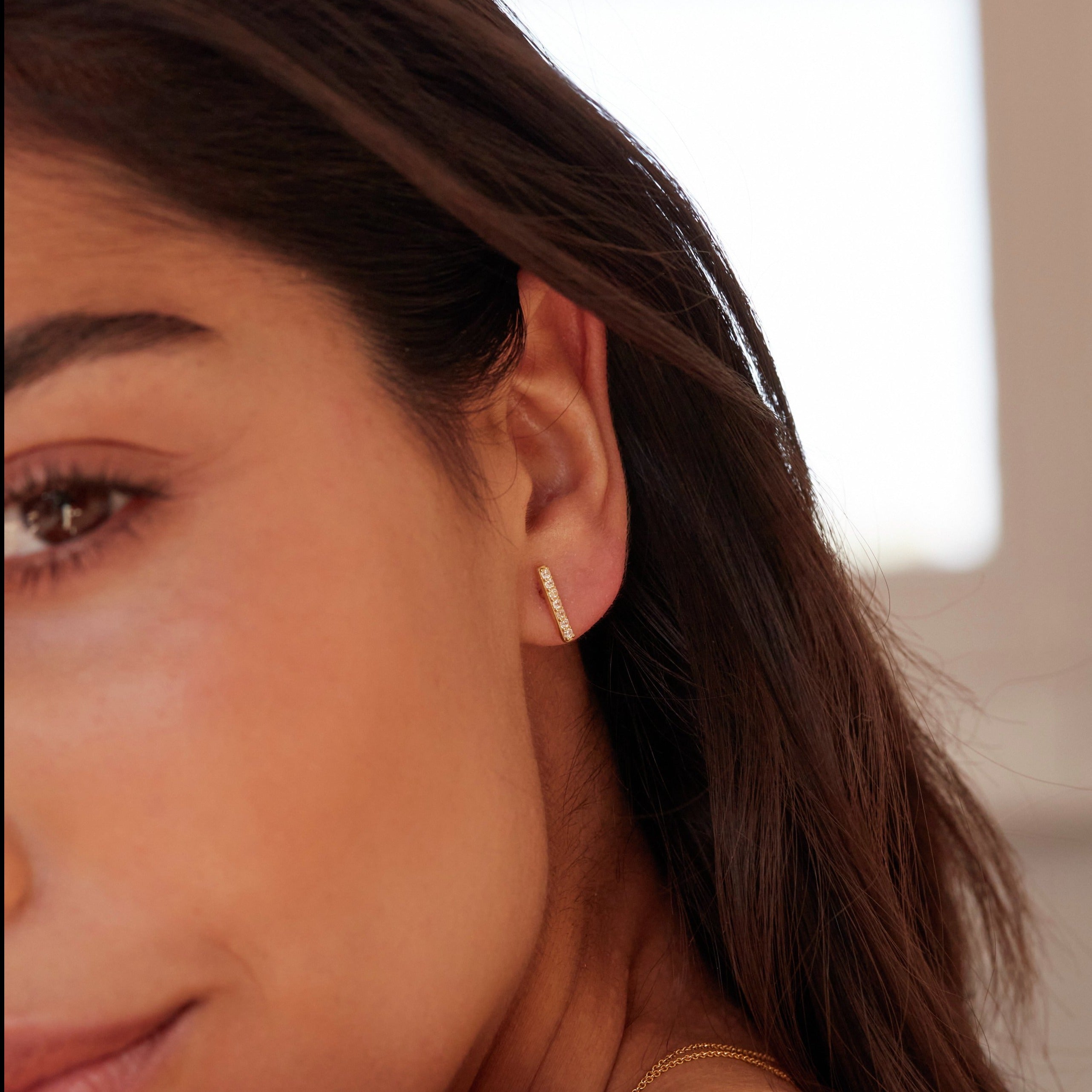 Silver diamond style bar stud earring in one ear lobe 