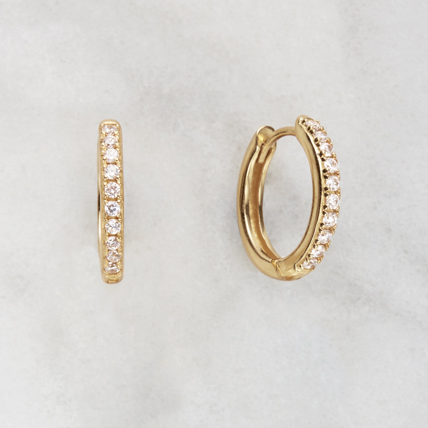 Gold diamond style large hoop earrings with a marble background