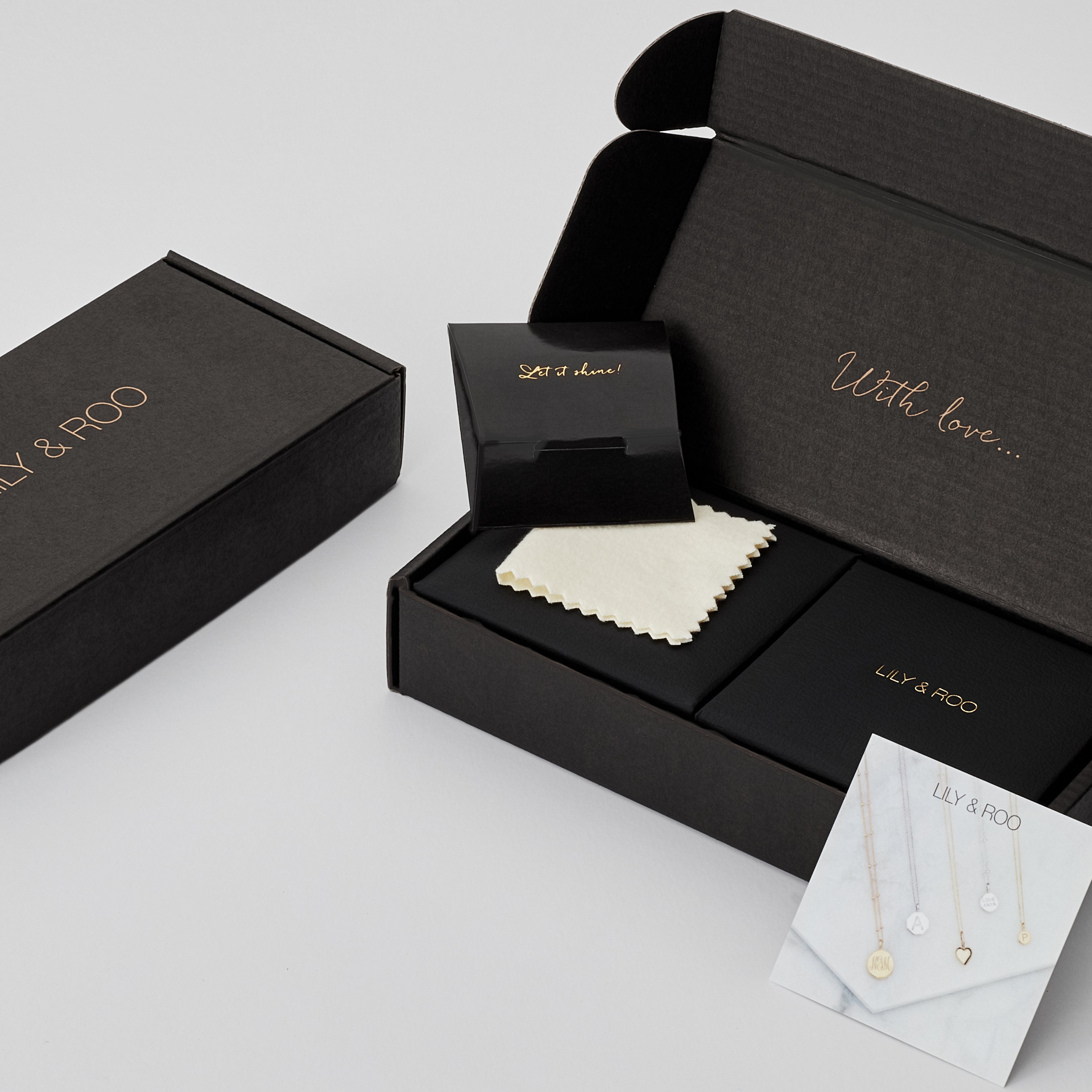 Open and closed black cardboard gift wrapping boxes of different sizes with the words 'LILY & ROO' and 'With Love' in gold
