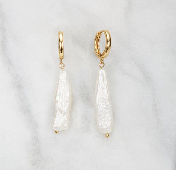 Gold baroque pearl shard hoop earrings on a marble surface