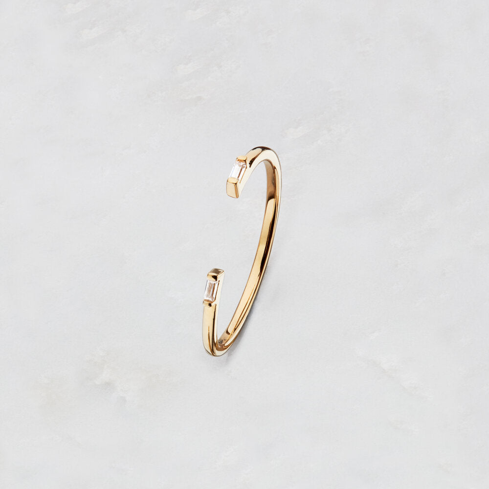 Gold Diamond Style Baguette Gap Ring on a marble surface