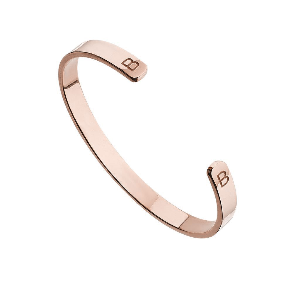 Gold thick engraved bangle with two of the letter 'B' engraved on a white background