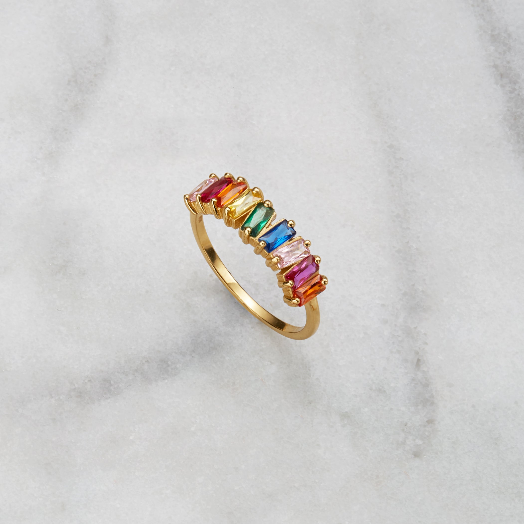 Gold rainbow gemstone cluster ring on a marble surface