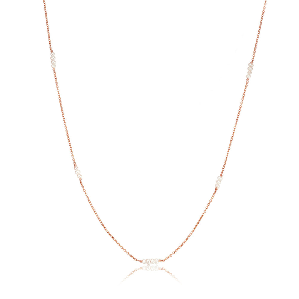 Rose gold mini pearl necklace on a white background