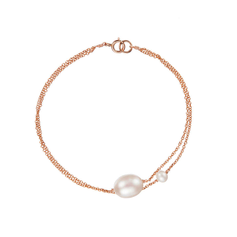 Rose gold layered large and small pearl bracelet on a white background