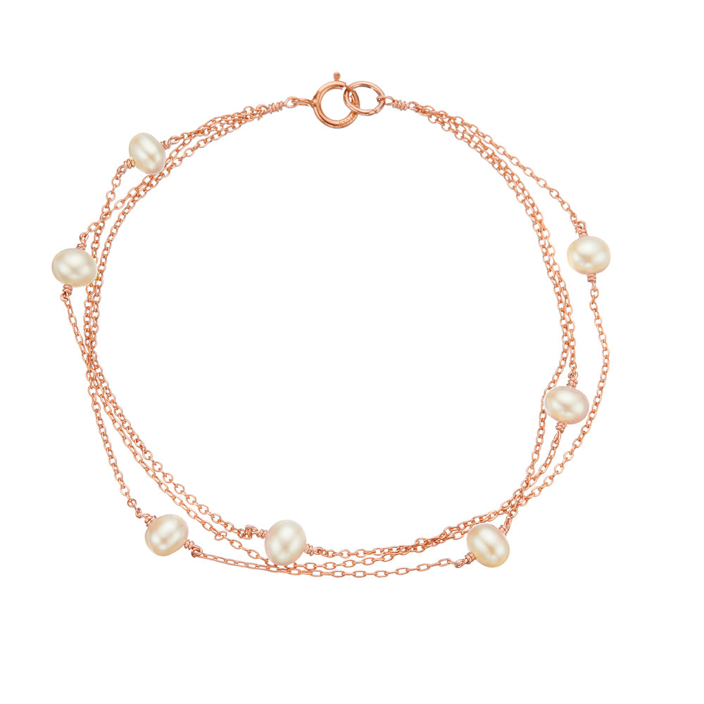 Rose gold layered pearl bracelet on a white background