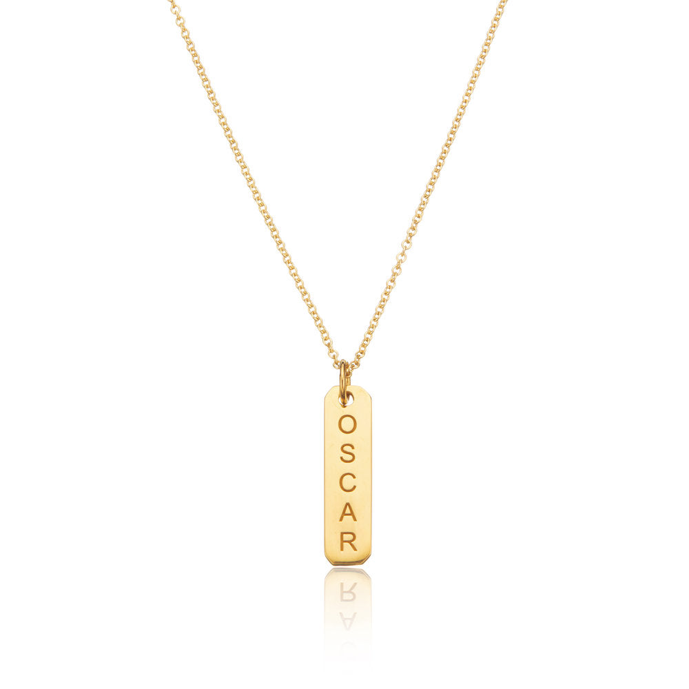 Gold personalised bar necklace with OSCAR engraved on it on a white background