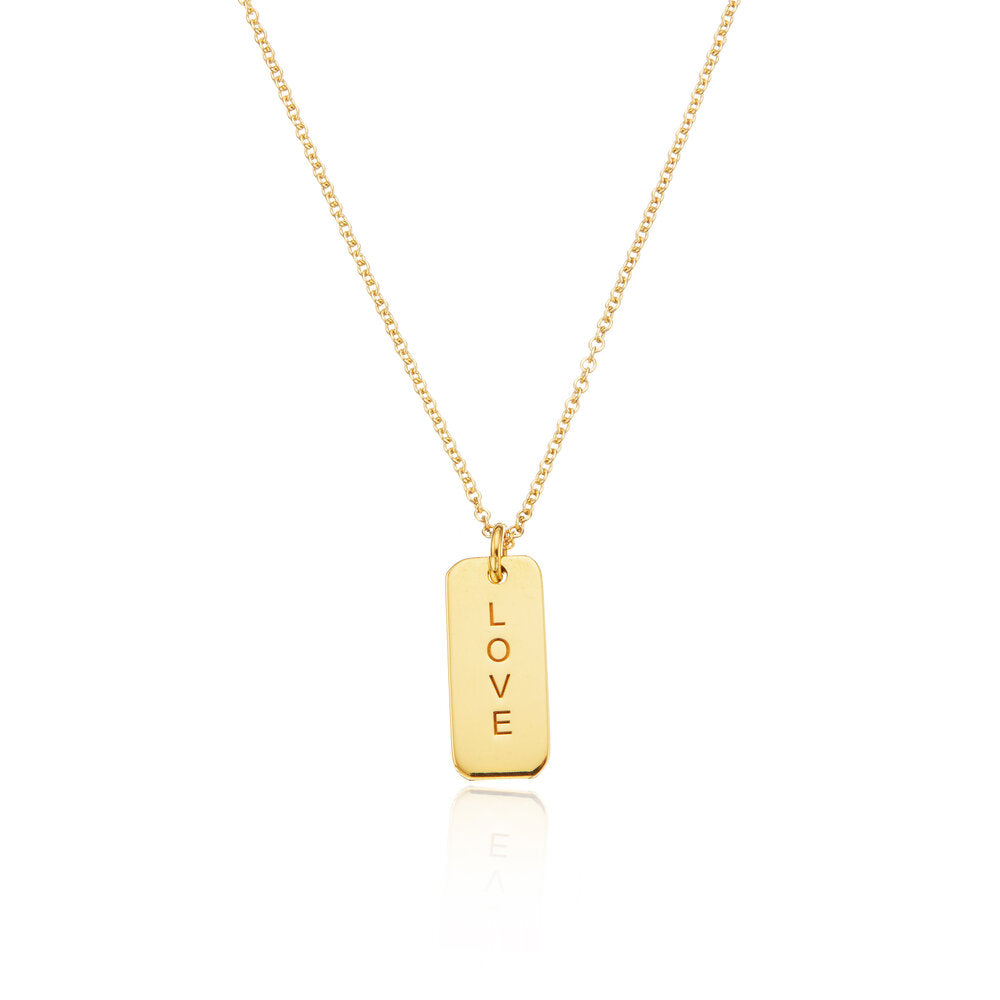 Gold personalised tag necklace with 'LOVE' engraved on it on a white background