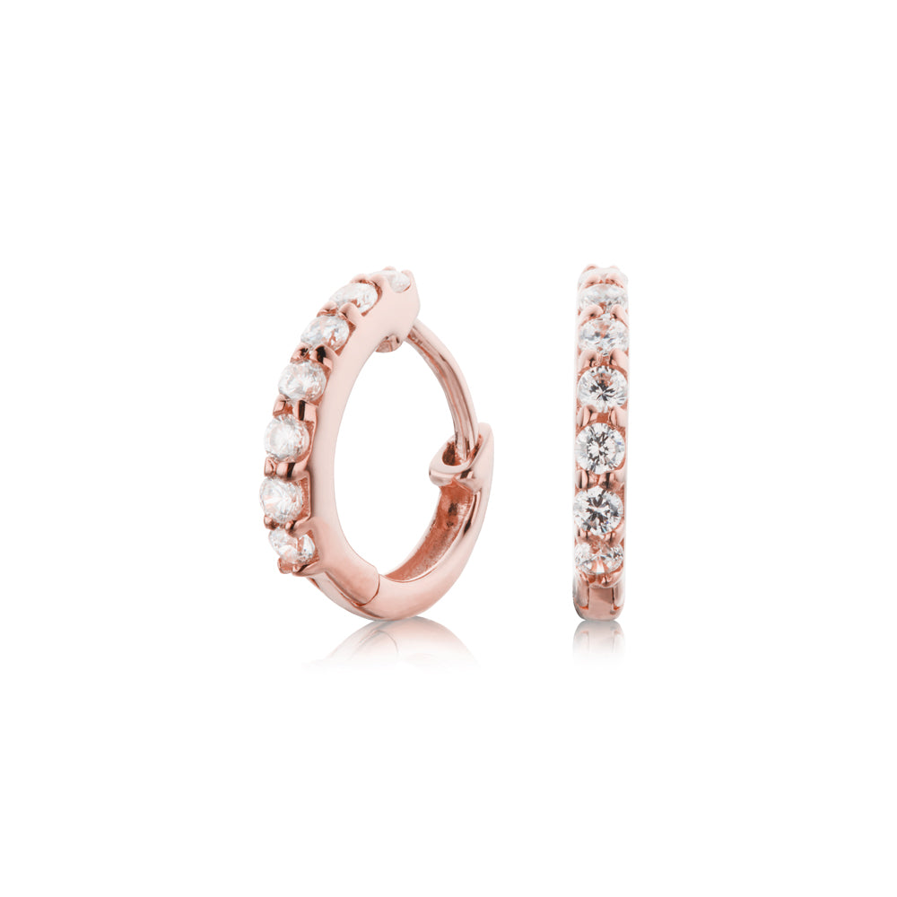 Rose gold diamond style huggie hoop earrings on a white background